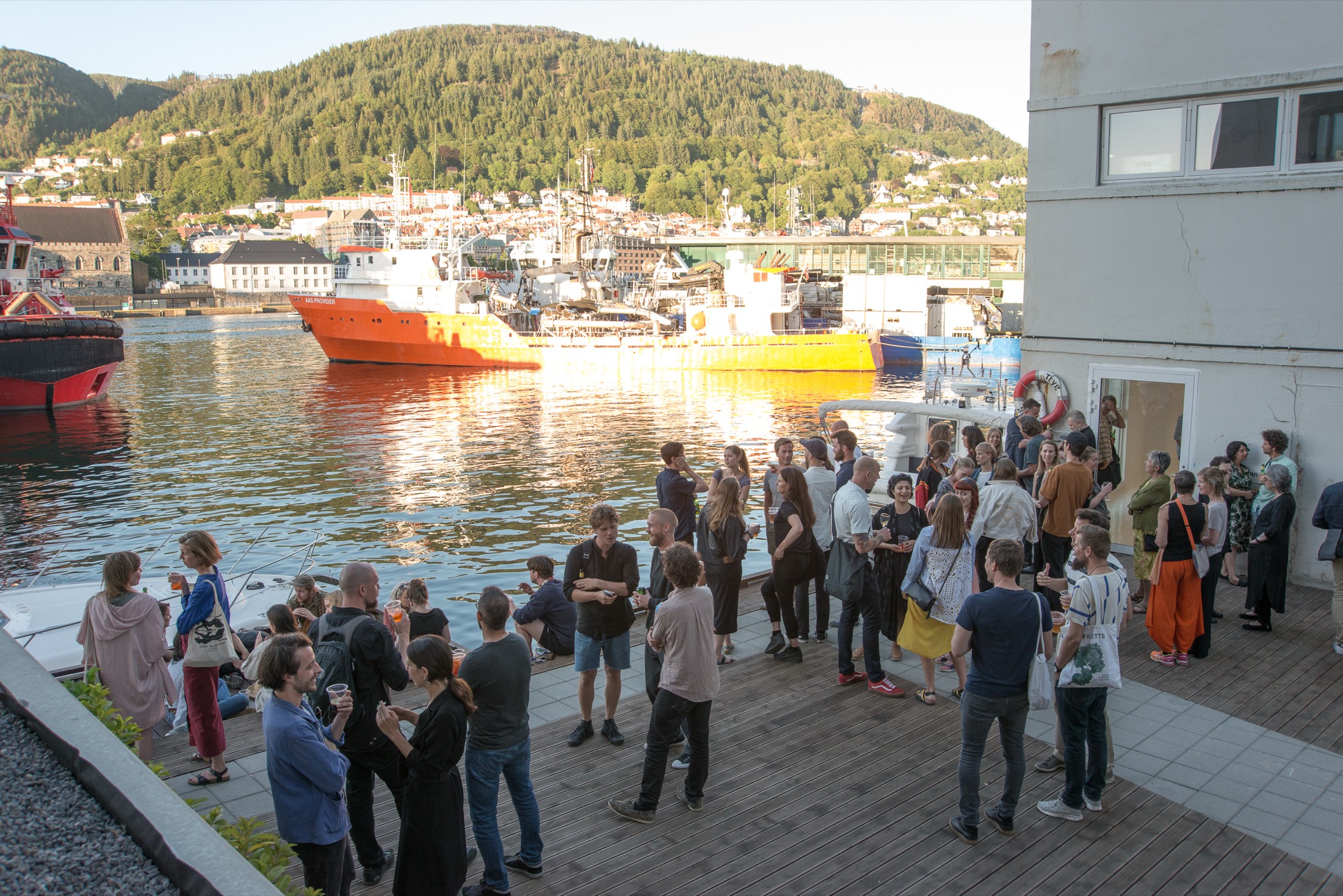 An opening-night crowd on the quay outside Aldea, Bergen harbour behind