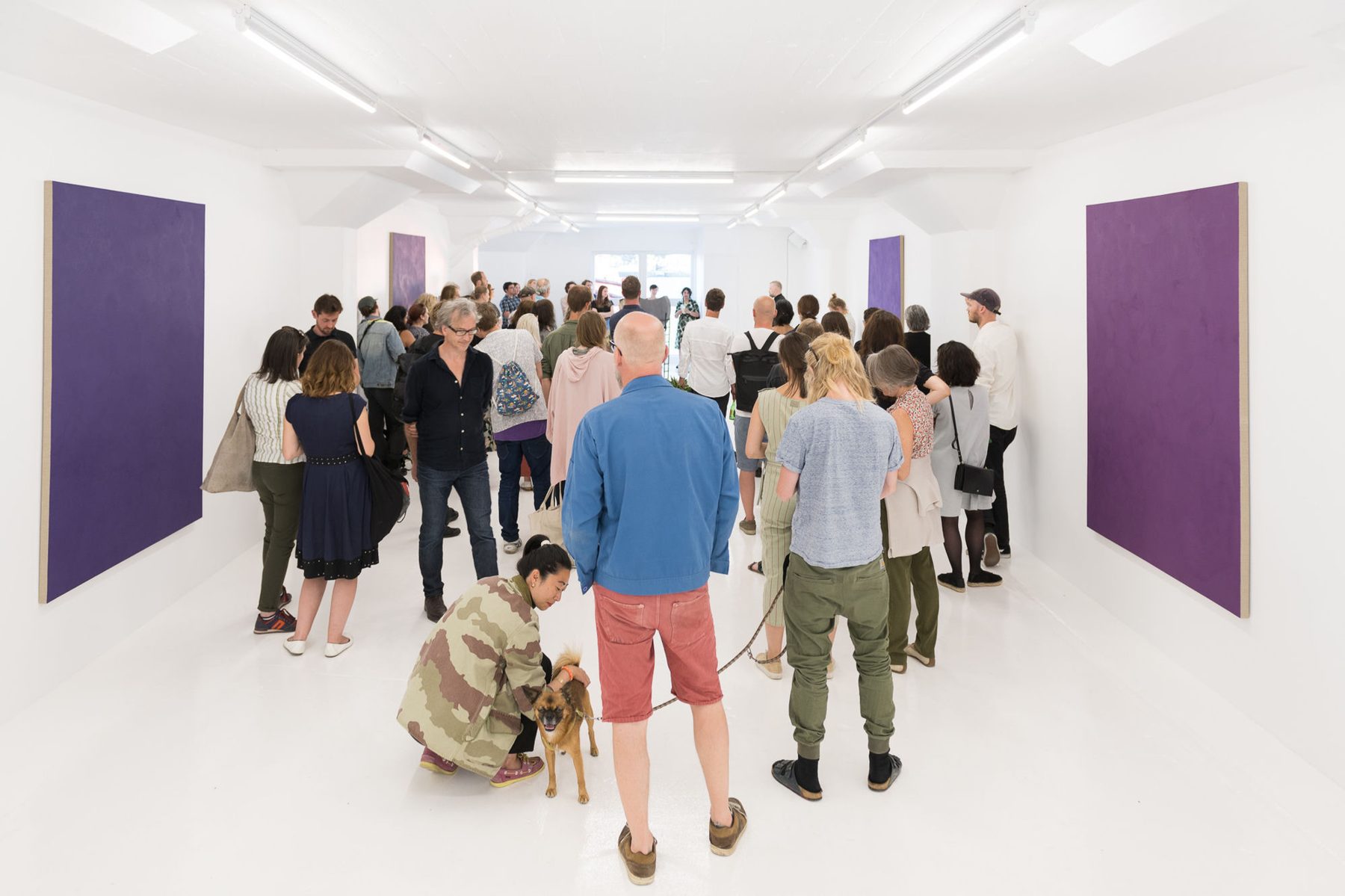 A crowded exhibition opening in the white gallery